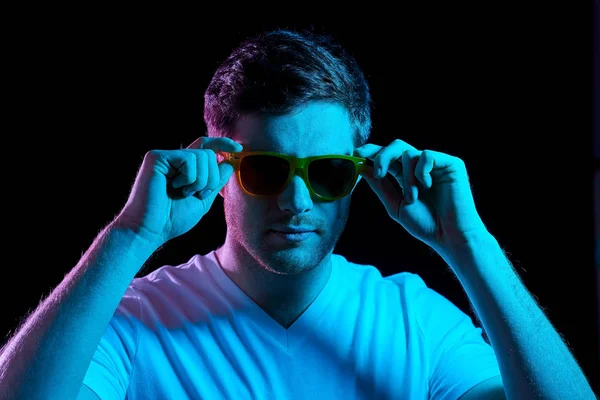 Uomo in occhiali da sole su luci al neon ultra viola — Foto Stock