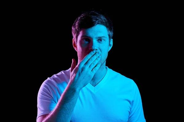 Homem cobrindo sua boca à mão em luzes de néon — Fotografia de Stock