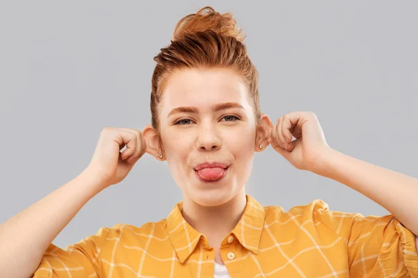 Sonriente pelirroja adolescente mostrando su lengua — Foto de Stock