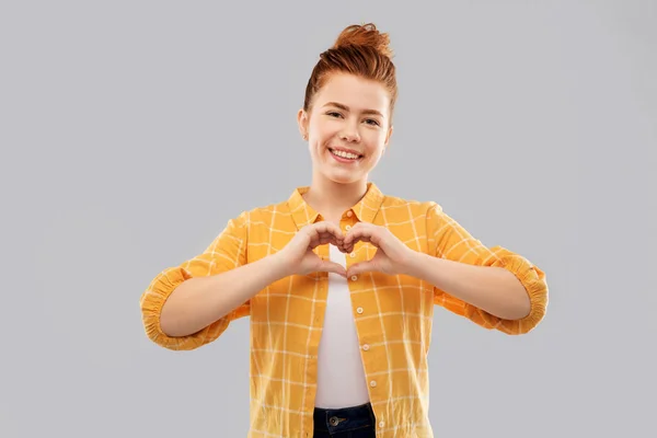 Leende röda haired tonårig flicka göra hand hjärta — Stockfoto
