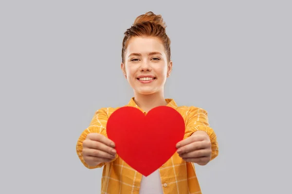 Smiling red haired teenage girl with heart — Stock Photo, Image