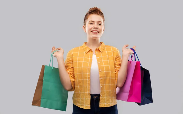 Lächelndes rothaariges Teenager-Mädchen mit Einkaufstüten — Stockfoto