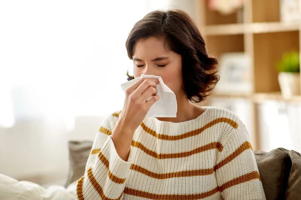 Zieke vrouw snuit neus in papieren weefsel thuis — Stockfoto