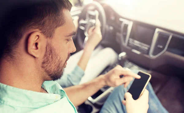 Homme et femme avec smartphones conduisant en voiture — Photo