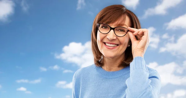 Porträtt av äldre kvinna i glasögon över grått — Stockfoto