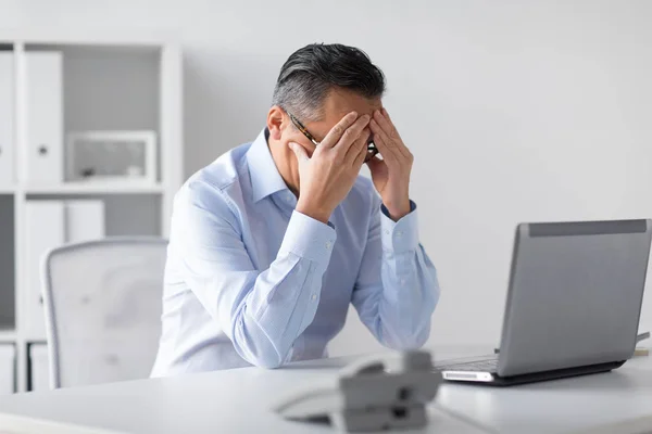 Benadrukt zakenman met laptop werken op kantoor — Stockfoto