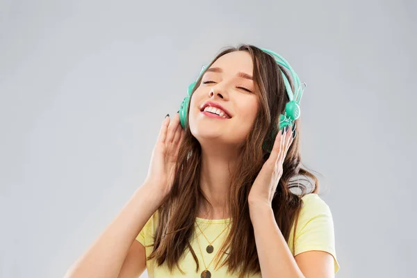 Щаслива молода жінка або дівчина-підліток з навушниками — стокове фото