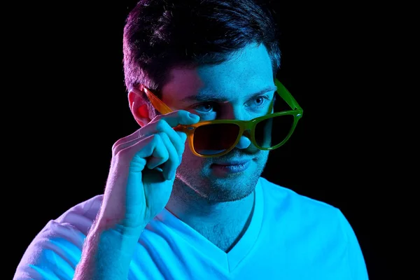 Muž v sluneční brýle přes ultra violet neonová světla — Stock fotografie
