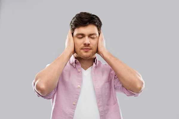 Homem fechando ouvidos por mãos — Fotografia de Stock