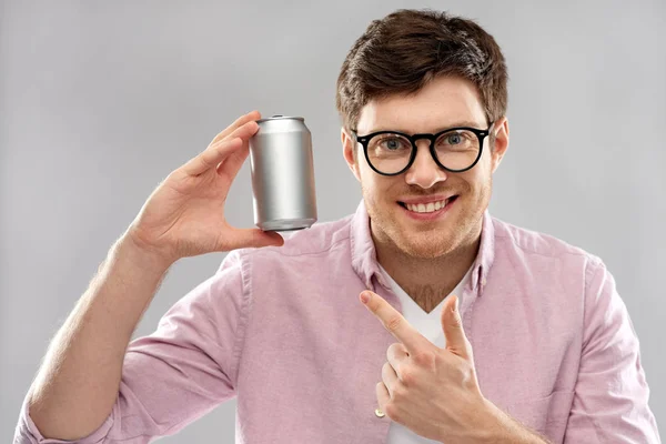 Feliz joven sosteniendo lata lata con soda — Foto de Stock