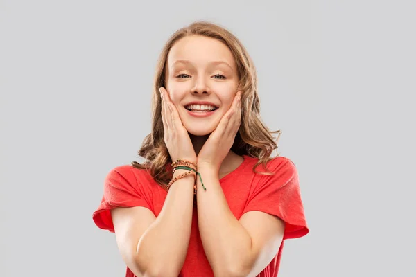 Sorridente adolescente menina em vermelho t-shirt sobre cinza — Fotografia de Stock