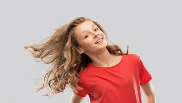 Adolescente souriante en rouge avec de longs cheveux ondulés — Photo