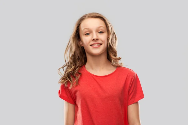 Sorridente adolescente menina em vermelho t-shirt sobre cinza — Fotografia de Stock