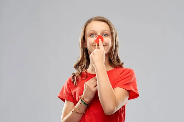 Sorridente adolescente com nariz de palhaço vermelho — Fotografia de Stock