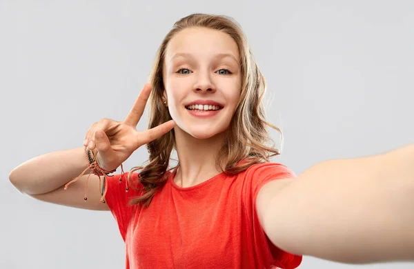 Lachende vrouw nemen selfie en tonen vredesteken — Stockfoto