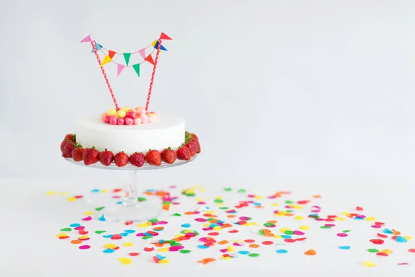 Zbliżenie na tort urodzinowy z garland na stoisku — Zdjęcie stockowe