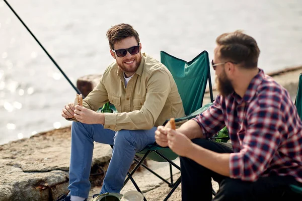 Amigos felizes pesca e comer sanduíches — Fotografia de Stock