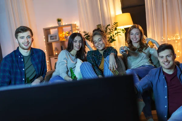 Amigos felices con bebidas viendo la televisión en casa —  Fotos de Stock