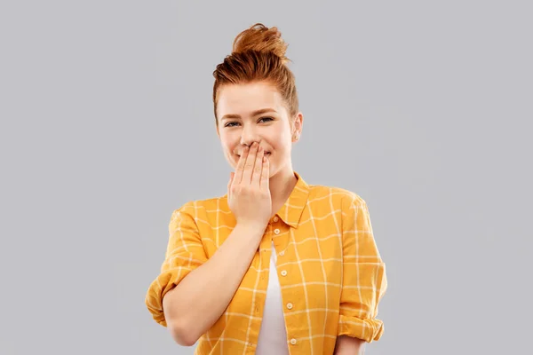 Confused red teenage girl covering mouth by hand — Stock Photo, Image