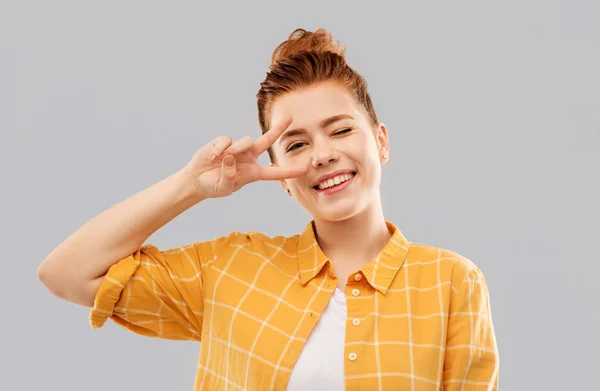 Smiling red haired teenage girl showing peace — Stock Photo, Image