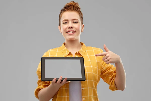 Röd haired tonårig flicka visar tablet PC — Stockfoto