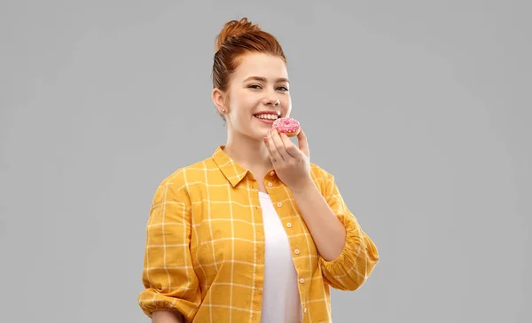 Χαμογελαστά κόκκινα μαλλιά κορίτσι εφηβική τρώει ντόνατ — Φωτογραφία Αρχείου