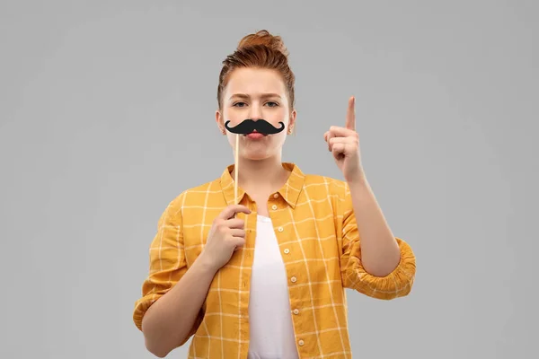 Teenagermädchen mit Schnurrbart zeigt mit dem Finger nach oben — Stockfoto