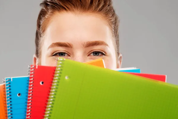 Primer plano de adolescente estudiante chica detrás de cuadernos —  Fotos de Stock