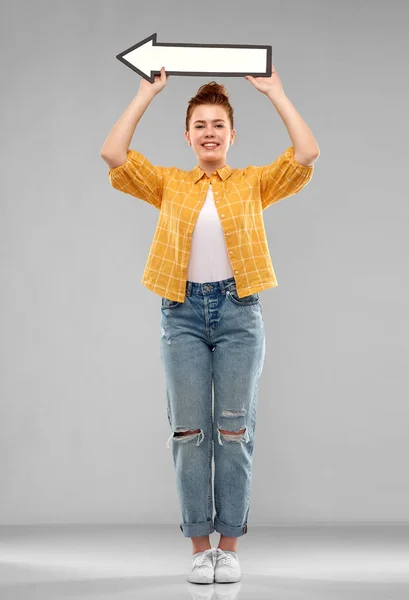 Red haired teenage girl with arrow showing to left — Stock Photo, Image