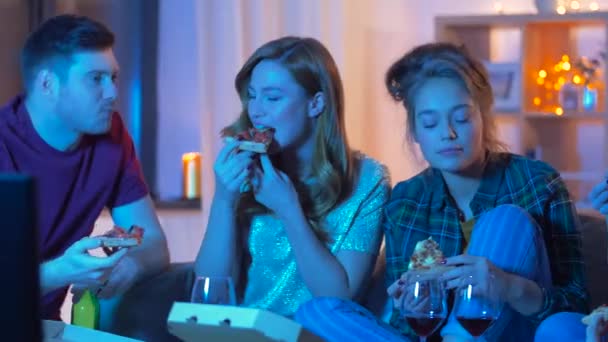 Φίλοι τρώγοντας πίτσα και πίνουν κρασί στο σπίτι — Αρχείο Βίντεο