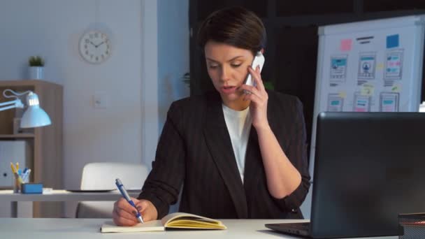 Business woman calling on smartphone at dark office — стоковое видео