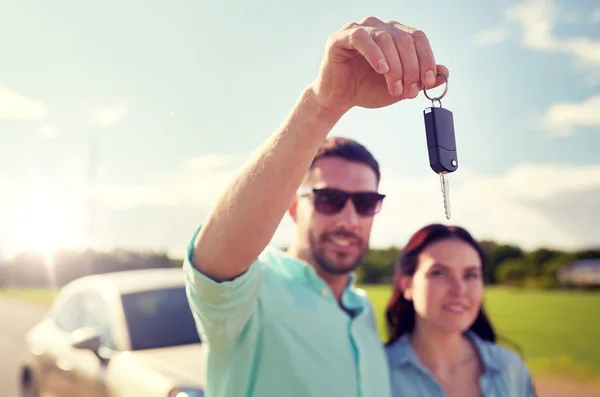 Homem feliz e mulher com chave do carro ao ar livre — Fotografia de Stock