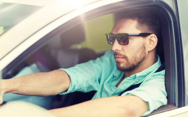 Güneş gözlüklü genç adam araba kullanıyor. — Stok fotoğraf