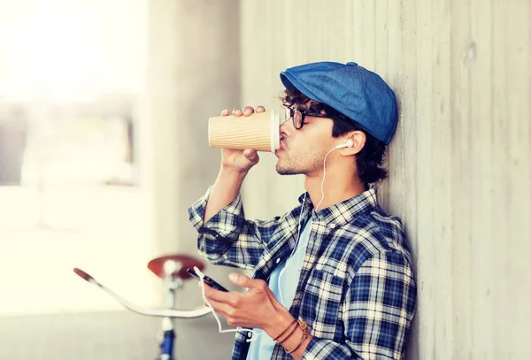 Mann mit Kopfhörer und Smartphone trinkt Kaffee — Stockfoto