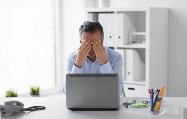 Homme d'affaires stressé avec ordinateur portable travaillant au bureau — Photo