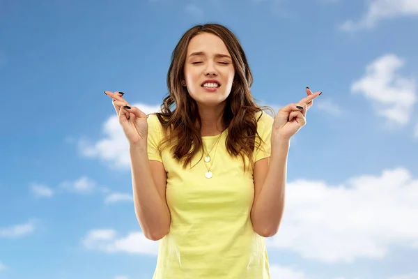 Jonge vrouw of tienermeisje met vingers gekruist — Stockfoto