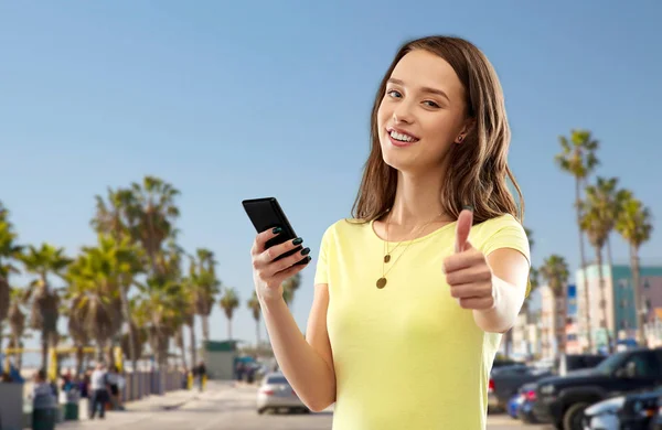 Tienermeisje met smartphone duimen opdagen — Stockfoto