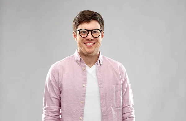 Sonriente joven en gafas sobre fondo gris —  Fotos de Stock