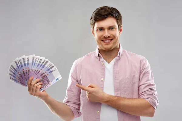 Jovem sorridente mostrando fã de dinheiro do euro — Fotografia de Stock