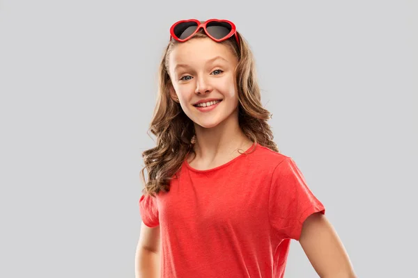 Heureuse adolescente en rouge coeur lunettes de soleil en forme — Photo