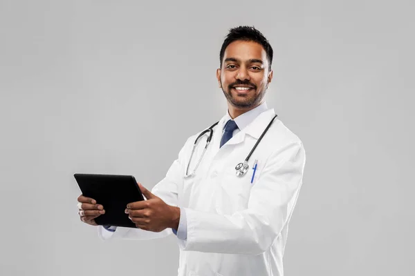 Smiling indian male doctor with tablet computer Stock Photo