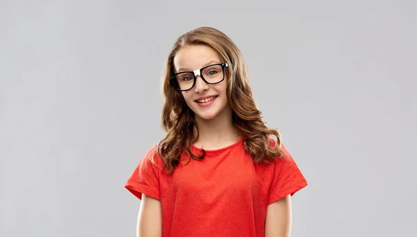 Niña estudiante sonriente en gafas y camiseta roja — Foto de Stock