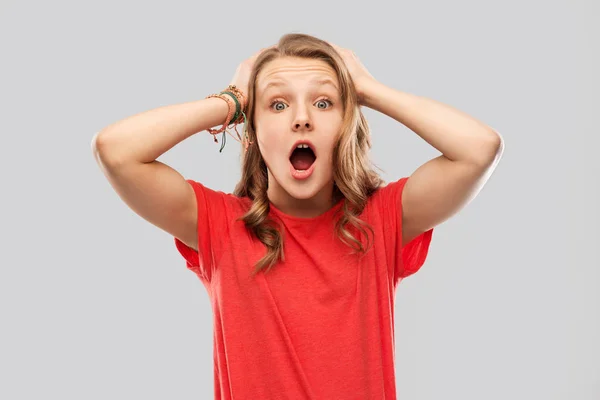 Impressed or shocked teenage girl in red t-shirt — Stock Photo, Image