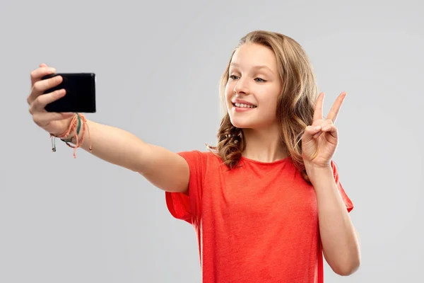 Mosolygó tizenéves lány vesz selfie, a smartphone — Stock Fotó