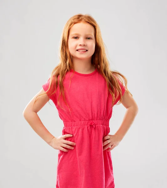 Uśmiechający się rudowłosy dziewczyna stwarzających w różowej sukience — Zdjęcie stockowe