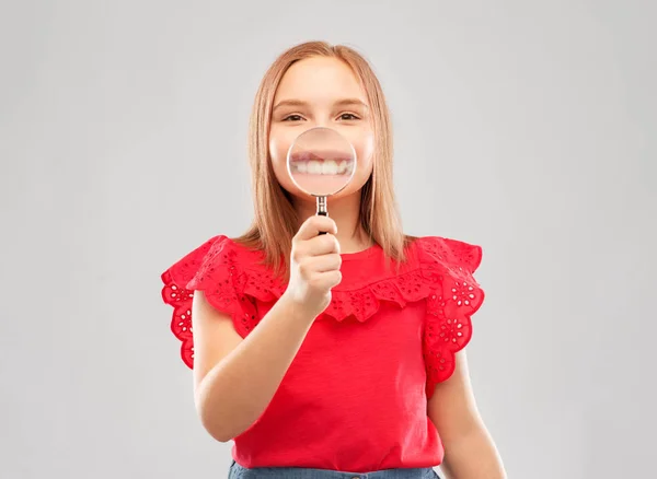 Gelukkig meisje met vergrootglas over haar tanden — Stockfoto