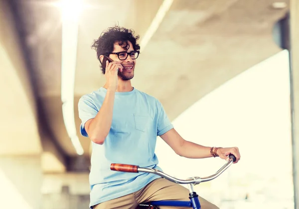 Hombre con teléfono inteligente y bicicleta de engranaje fijo en la calle —  Fotos de Stock