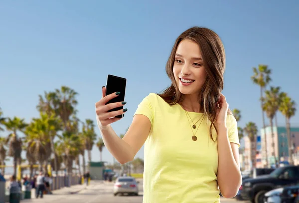 Teen girl takes selfie by cell over venice beach — Stock Photo, Image