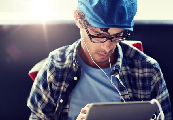 Man met tablet pc en de koptelefoon zit op café — Stockfoto