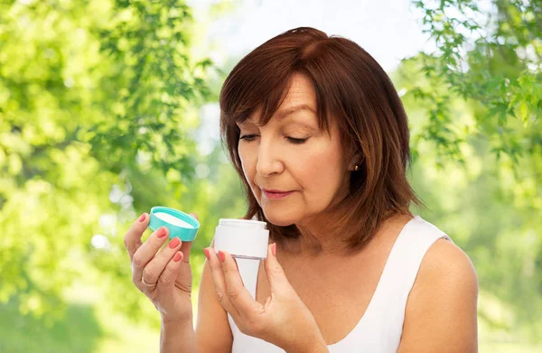 Senior woman with cream jar — Stock Photo, Image